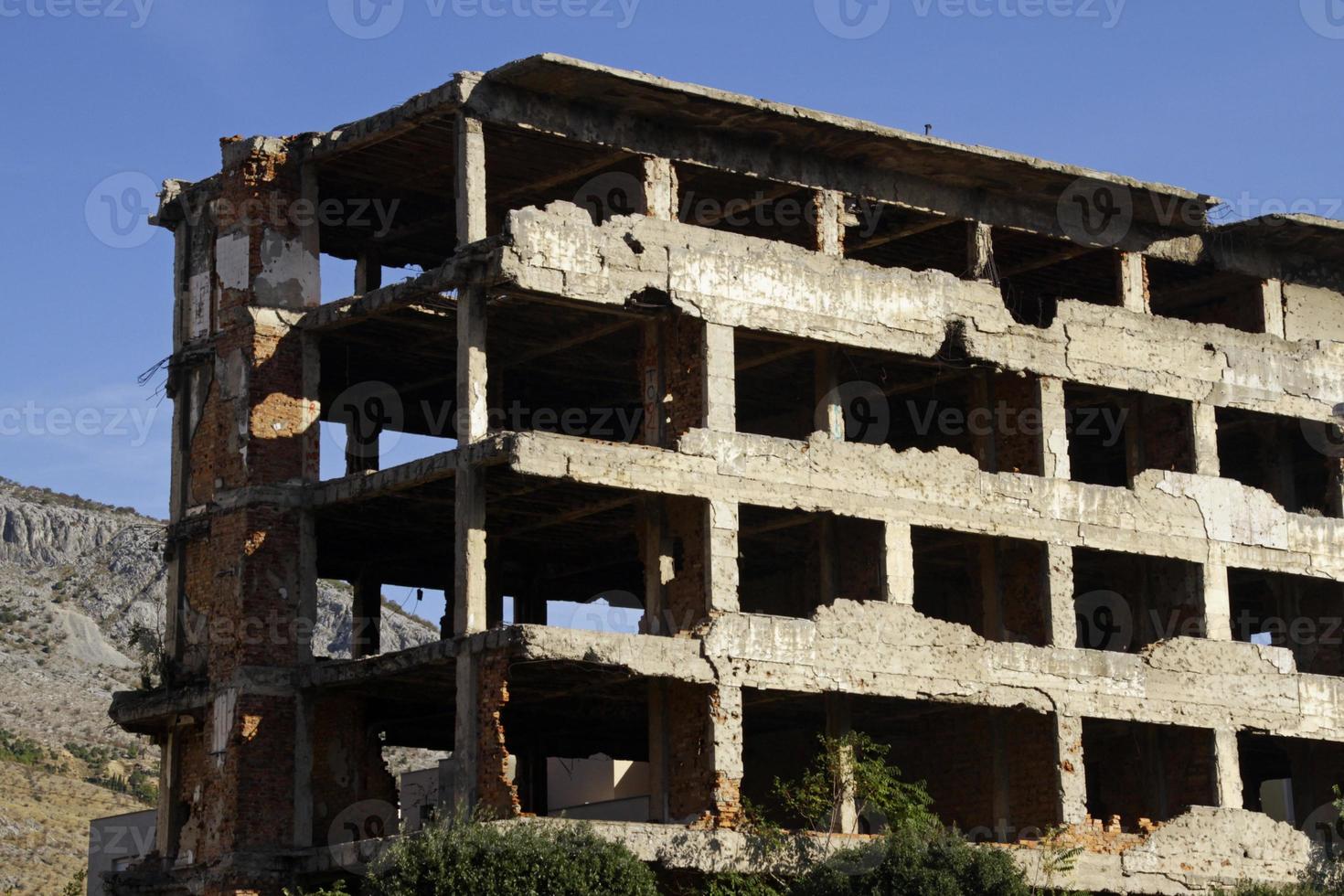 Ruin in the city of Mostar, Bosnia and Herzegovina, with visible bullet holes and mortar shrapnel marks photo