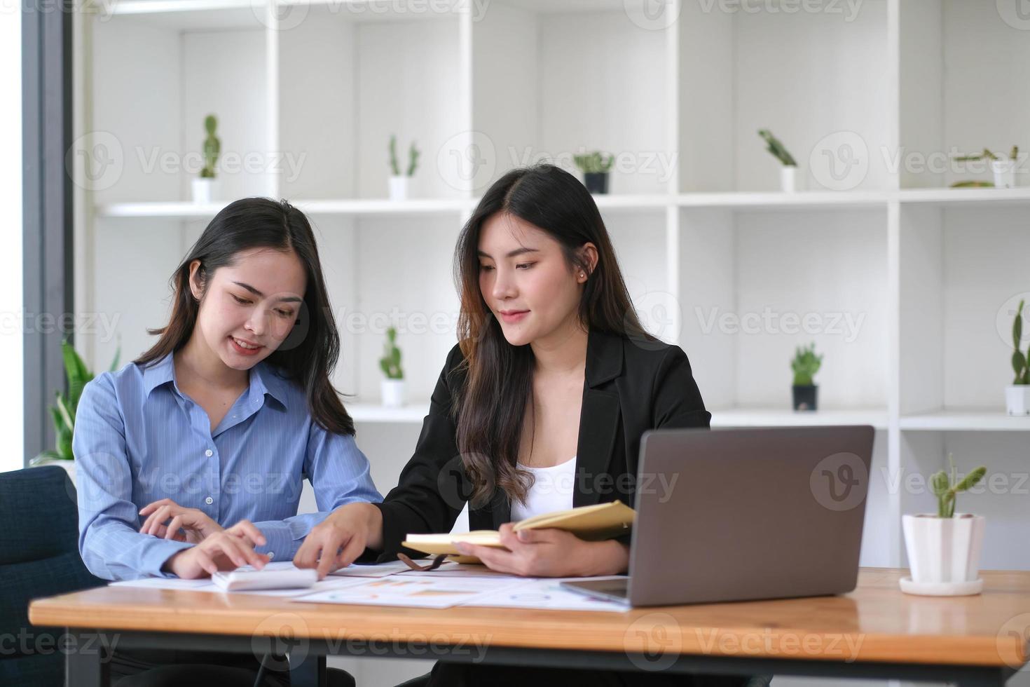 dos jóvenes empresarias asiáticas discuten con la presentación de una nueva idea de proyecto de inicio, analizan la planificación y las estadísticas financieras y el mercado de inversión en la oficina. foto