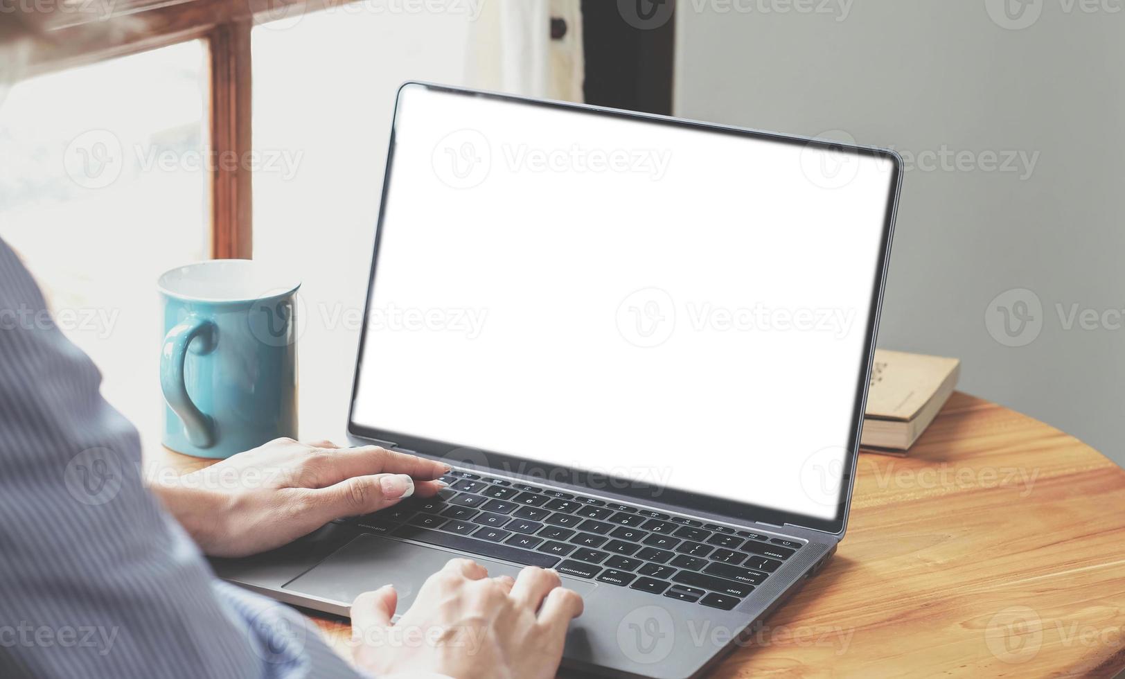 primer plano, mujer de negocios usando una computadora portátil en su escritorio. maqueta de pantalla en blanco de computadora portátil foto