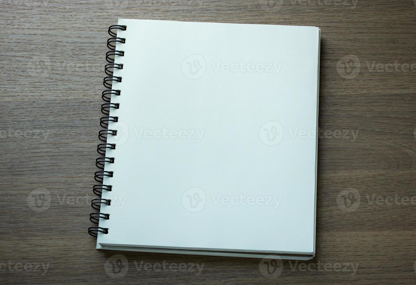 blank spiral notebook on dark wood background photo