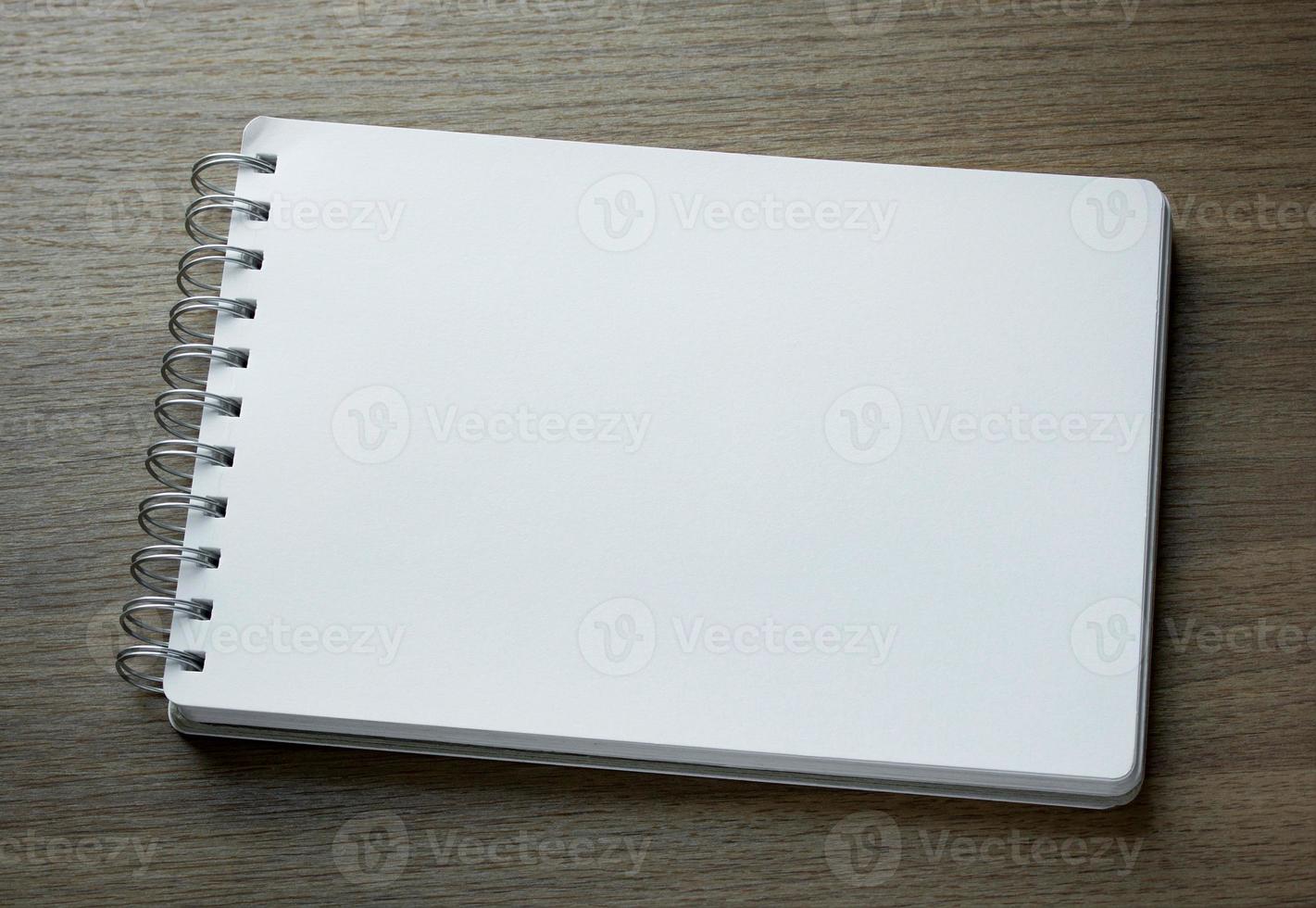 blank spiral notebook on dark wood background photo