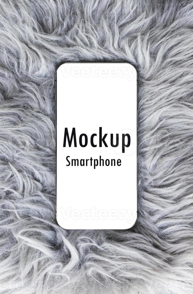 Smartphone with mockup white screen and clipping path on gray wool rug photo