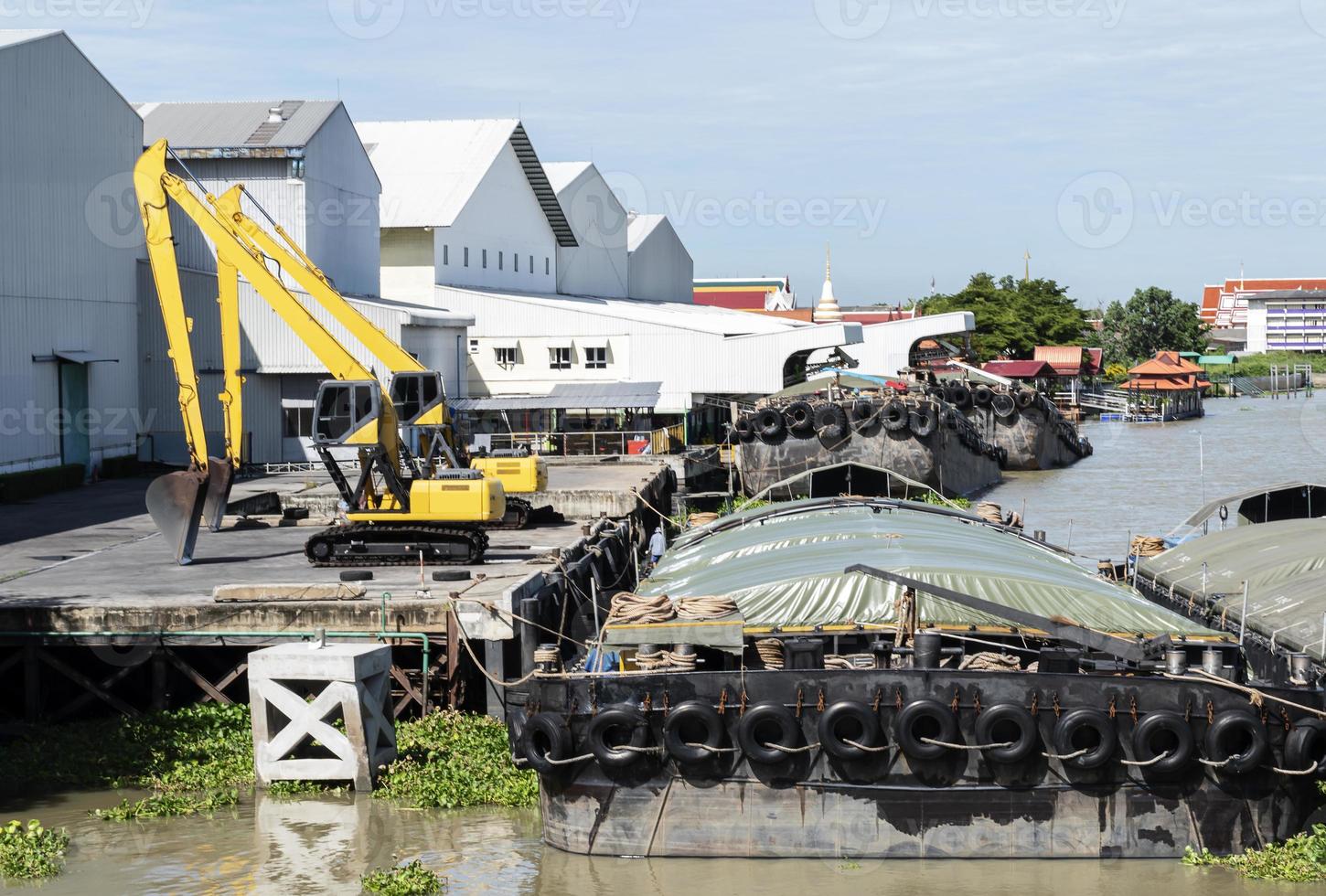 Two yellow backhoe on dock and barges photo