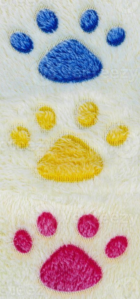 Wool rug texture with colorful cat footprints pattern background photo