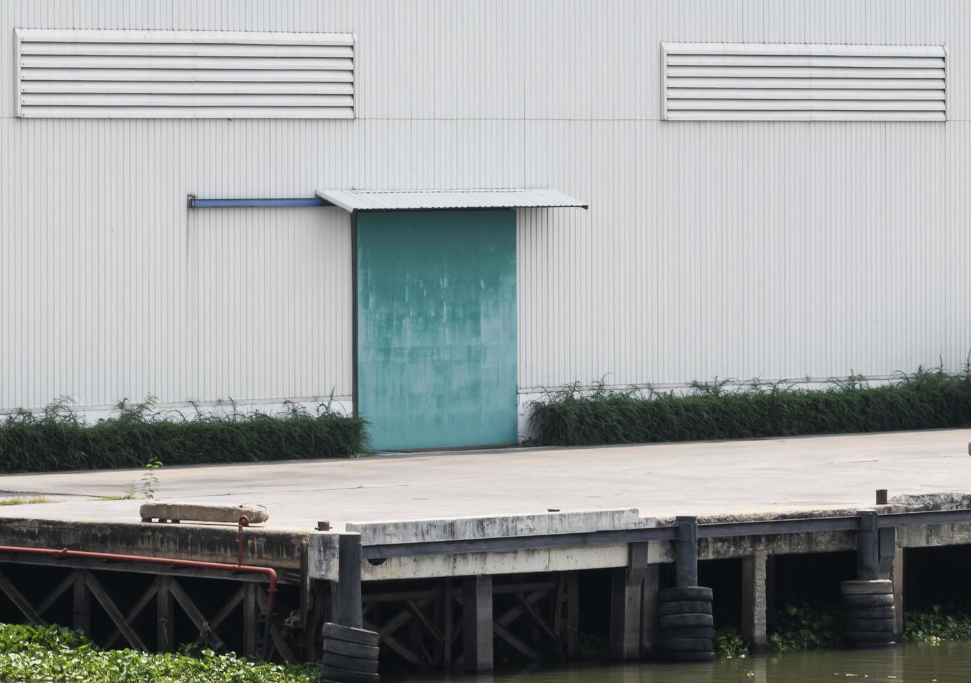 White warehouse building with green door at port photo