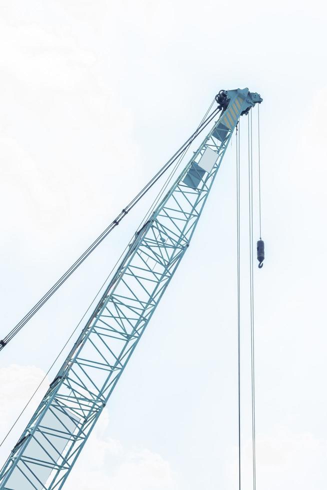 Large green crane boom with hooks with sky background photo