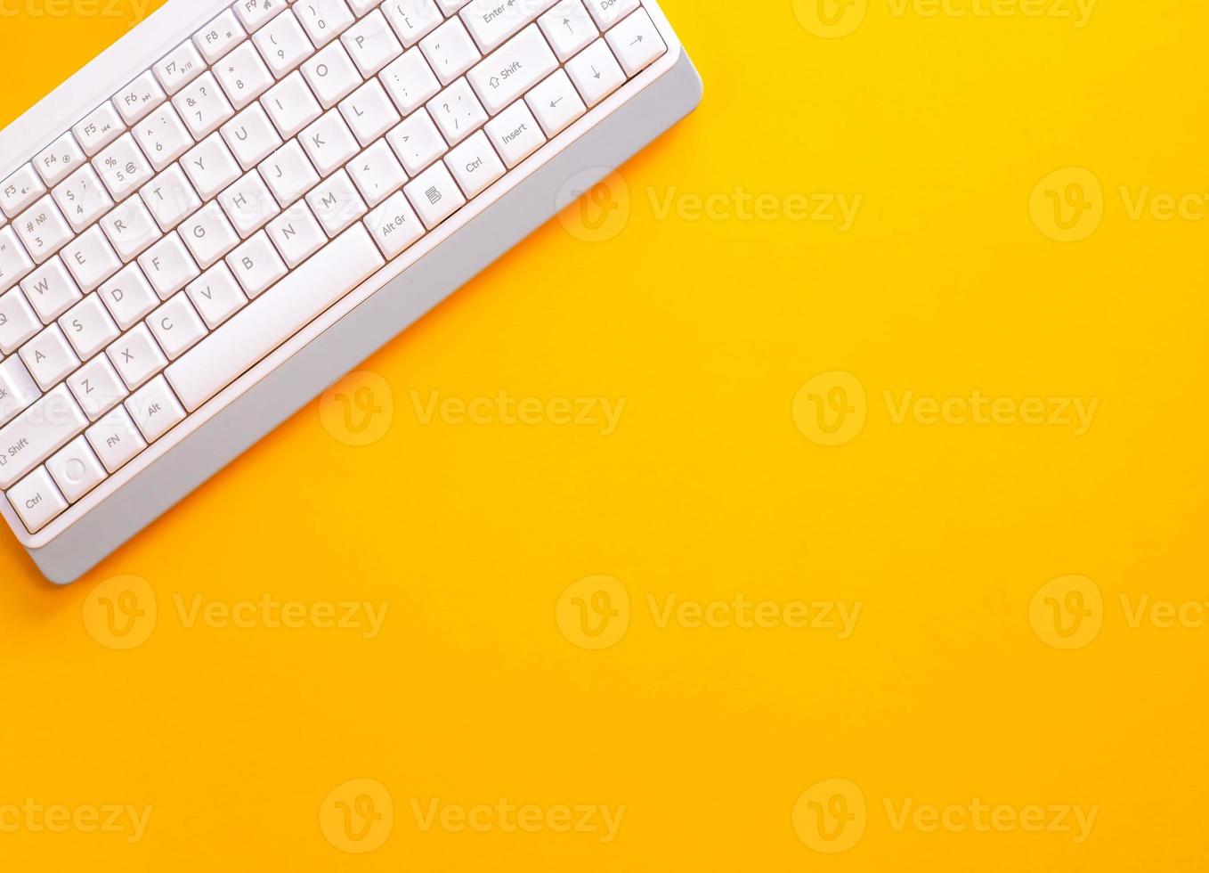 Modern white keyboard on yellow background, great design for any purpose. Flat PC symbol. Top view, copy space photo