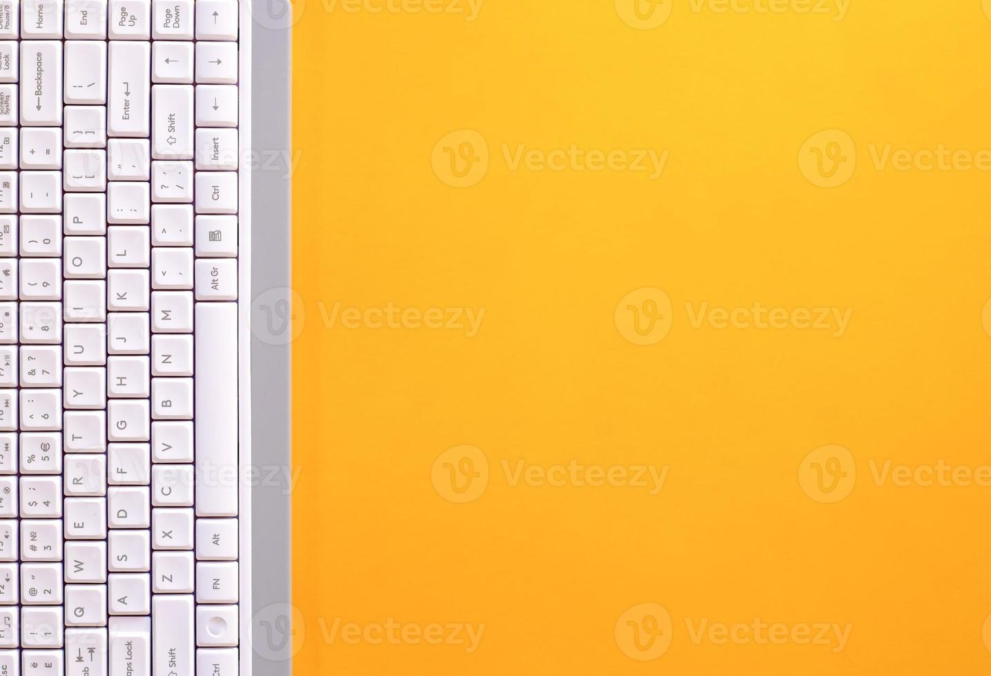Modern white keyboard on yellow background, great design for any purpose. Flat PC symbol. Top view, copy space. vertical arrangement photo