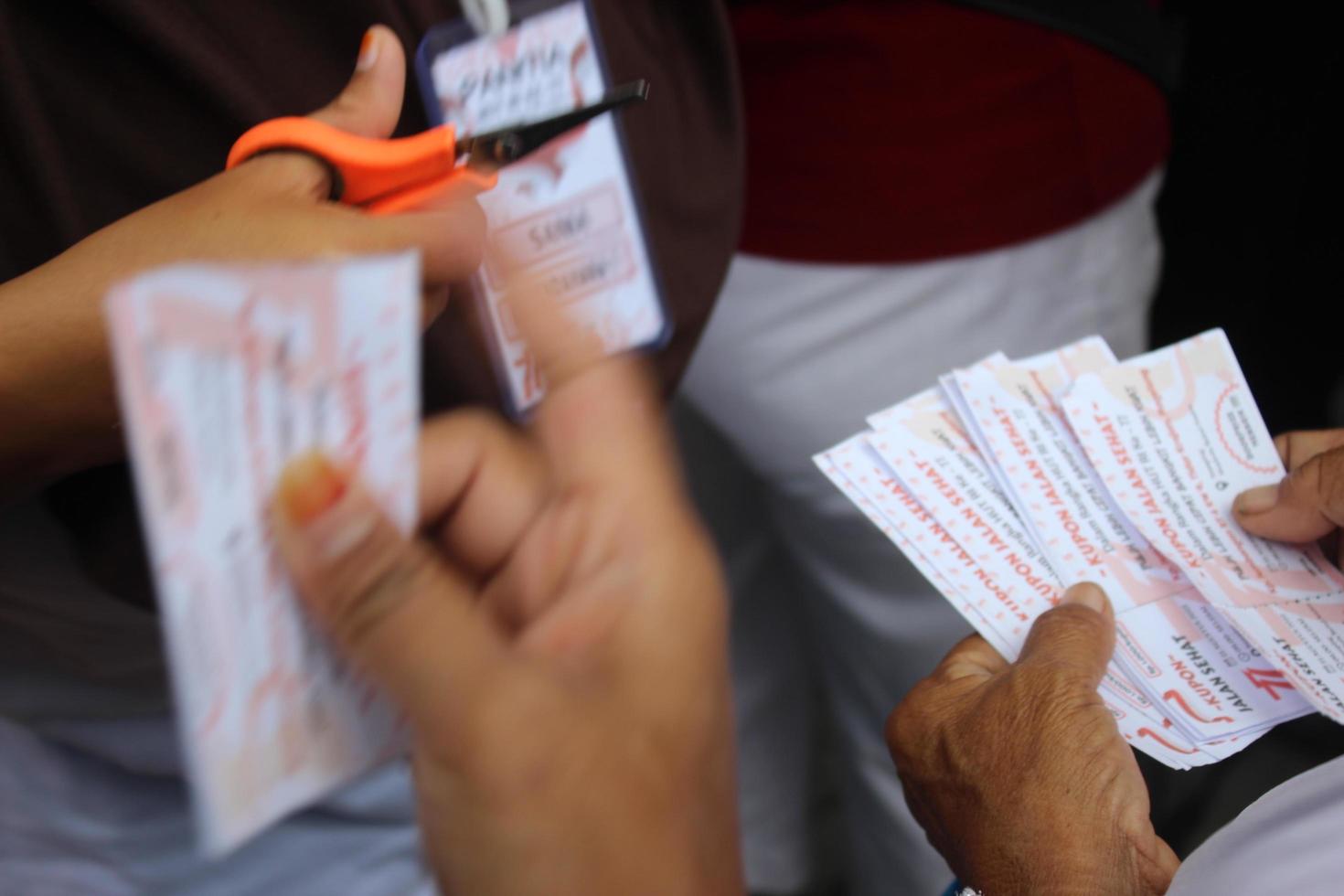 Magelang, Indonesia ,21 07 2022.hands holding healthy walk tickets to exchange for drinks. photo