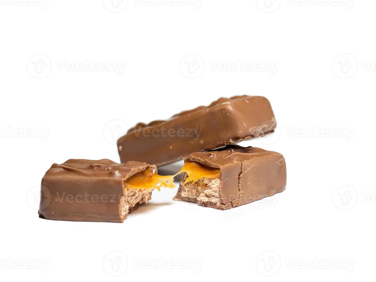 barra de chocolate rota sobre un fondo blanco. rebanadas de chocolate foto