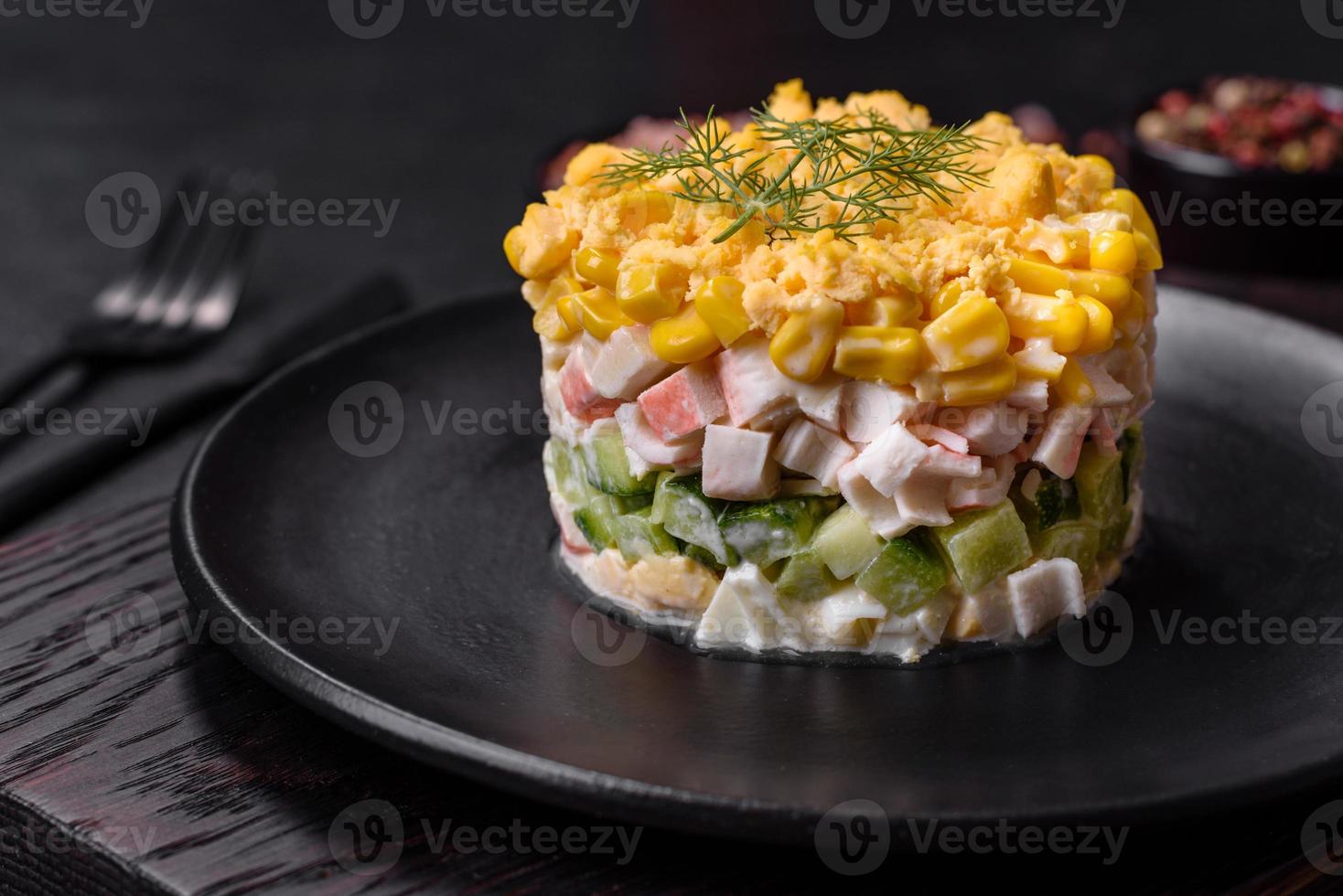 Fresh vegetable salad with corn, pepper, crab, cucumber, eggs and mayonnaise photo