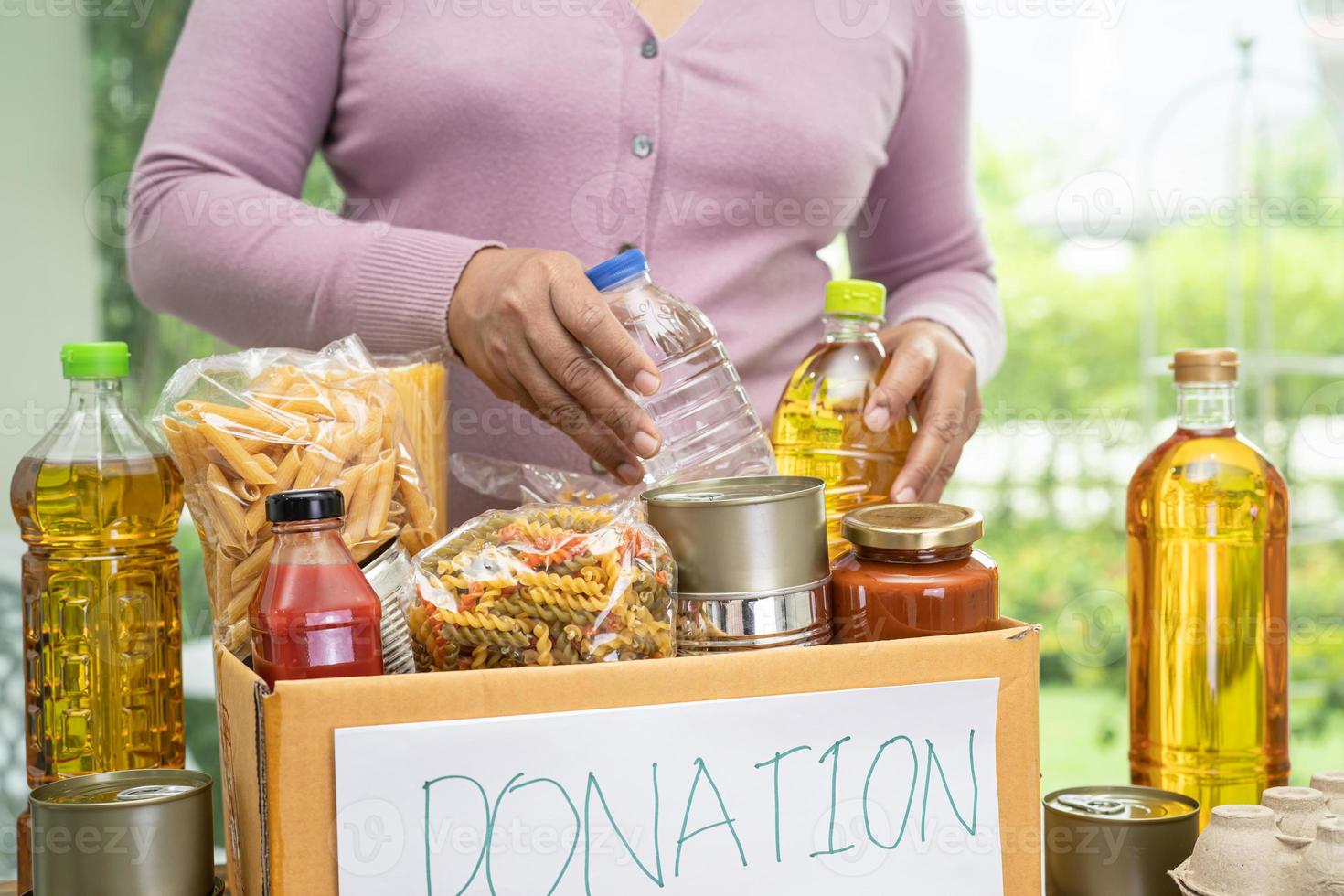 Foodstuff for donation, storage and delivery. Various food, pasta, cooking oil and canned food in cardboard box. photo