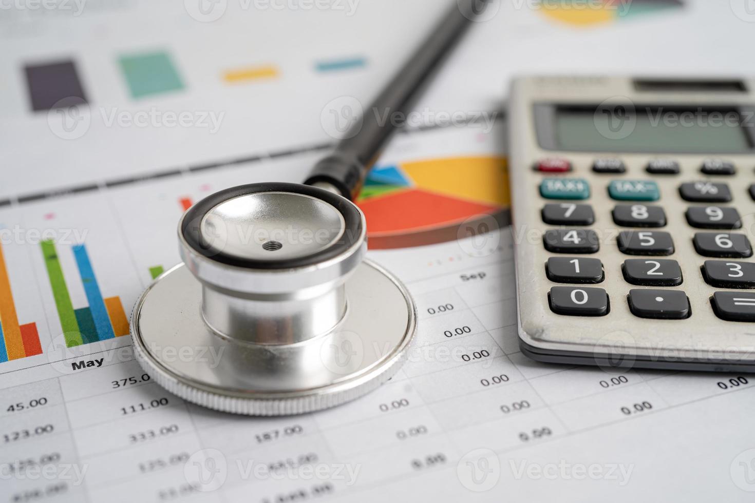 Stethoscope with calculator on chart graph paper, finance, account, statistic, analytic economy Business concept. photo