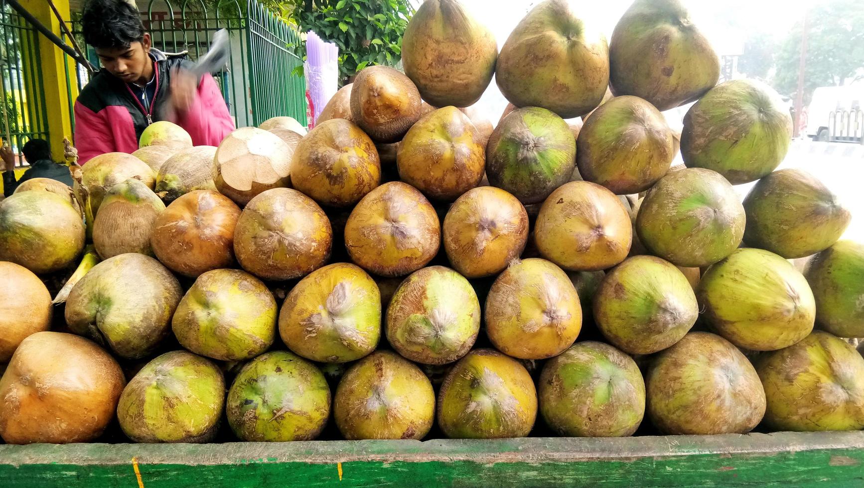 Mumbai, India - December, 2019 Street Vendor - close-up of man cutting tender coconut photo