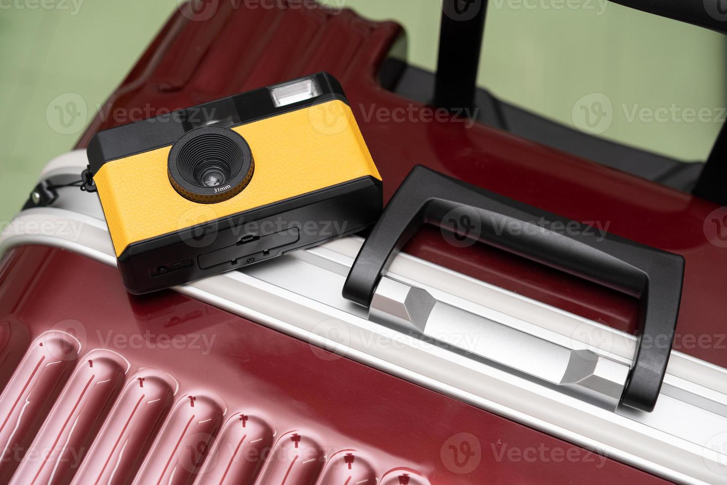 Travel Concept vintage camera on red luggage gray background, with copy space. Suitcase and retro film camera travel concept. photo