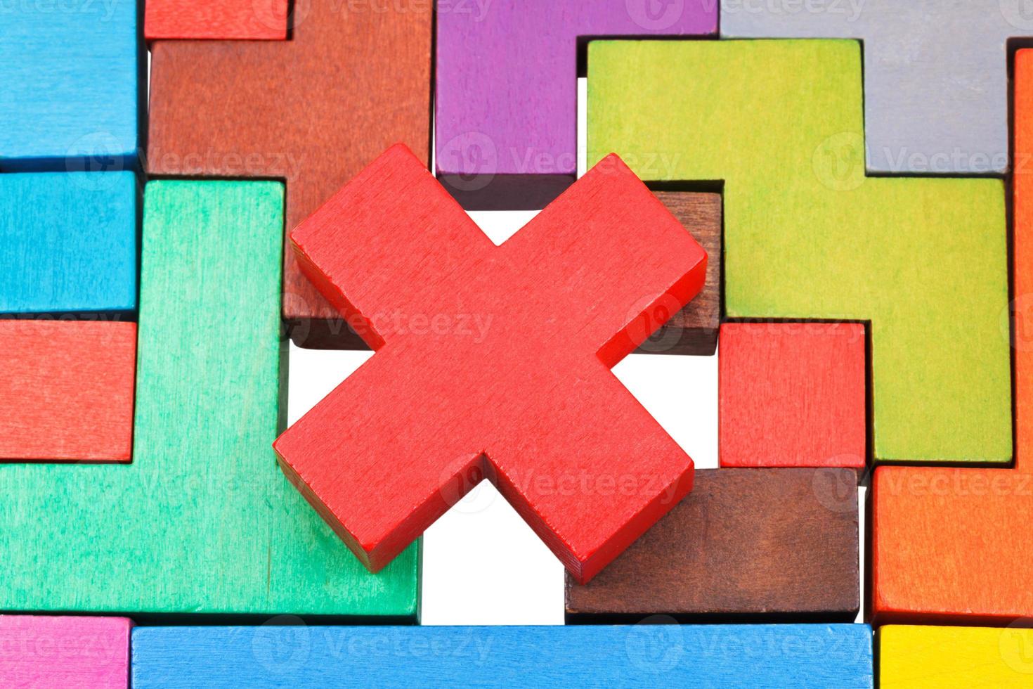 cross shaped piece on multicoloured puzzle photo