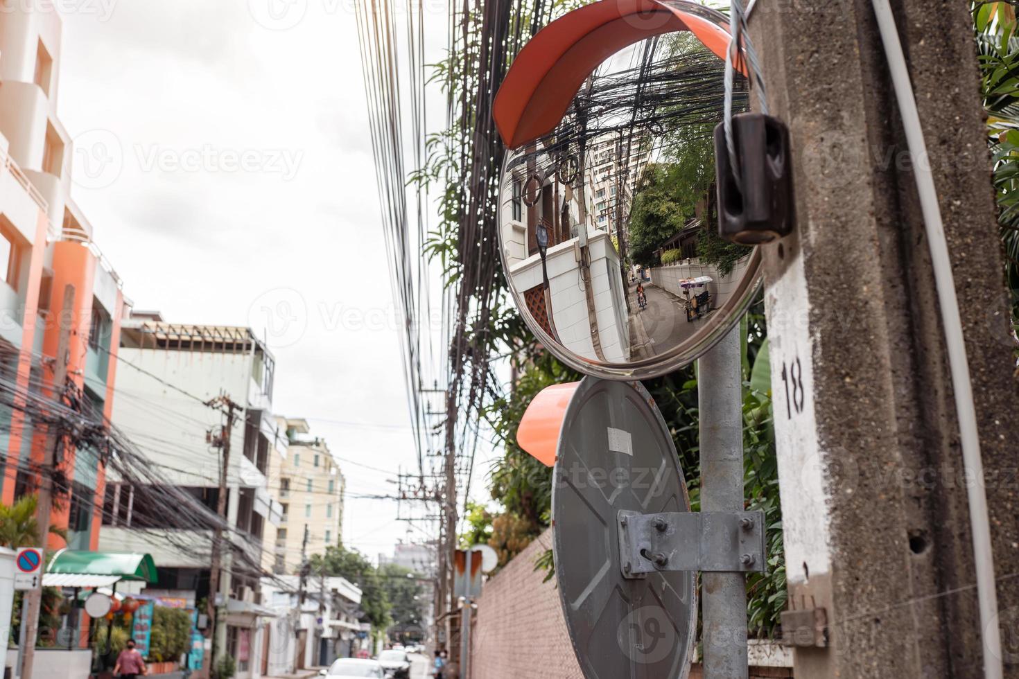 Convex mirror on pole on public road, Round Security Mirror for safety of entrances and exits or curves that are difficult to see, Road traffic safety concept photo