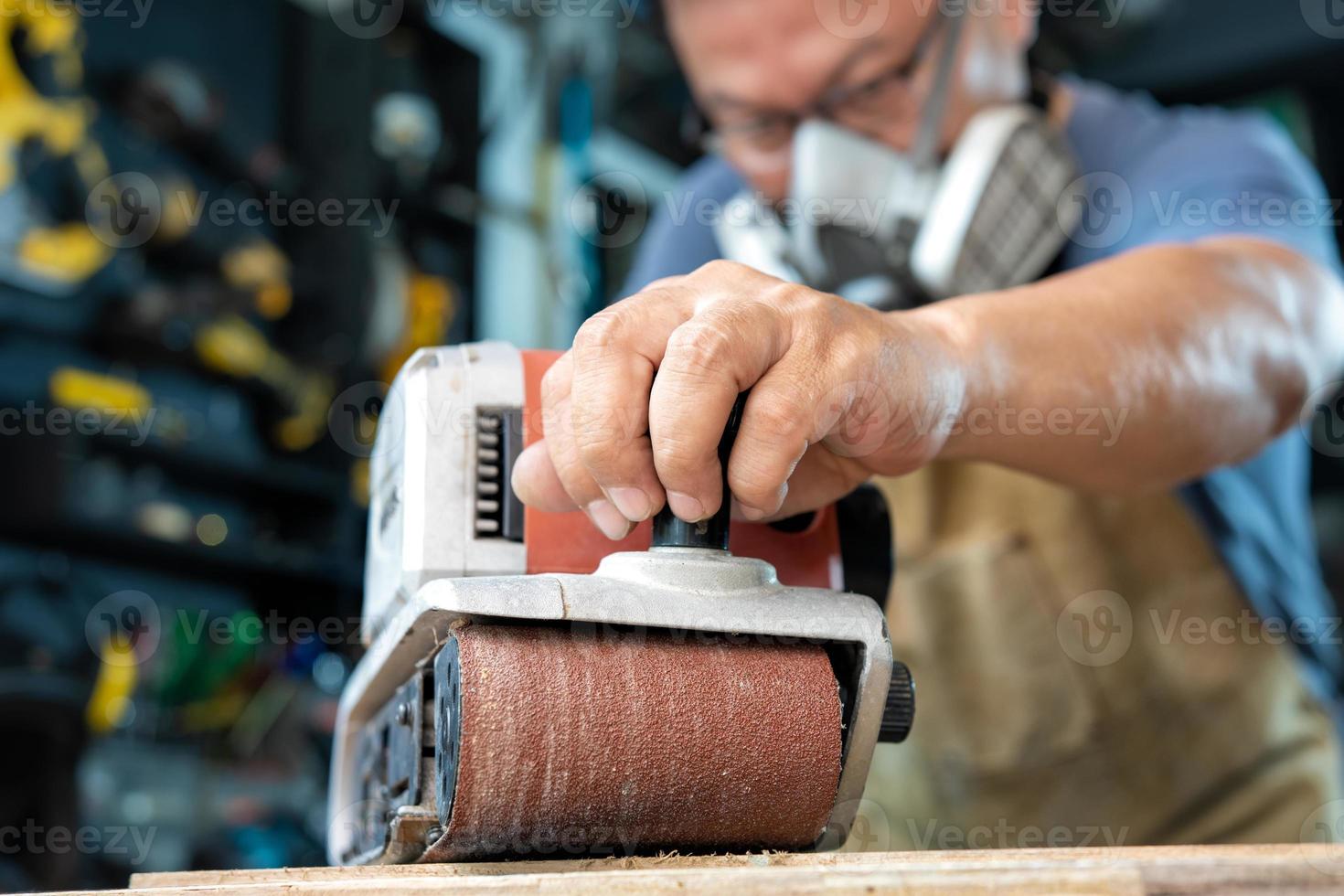 carpenter working with belt sander polishing on wooden in workshop ,DIY maker and woodworking concept. selective focus photo