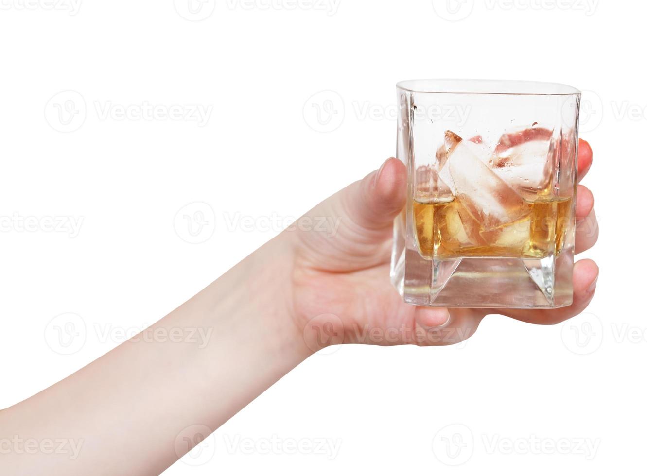 la mano sostiene el vaso con whisky aislado foto