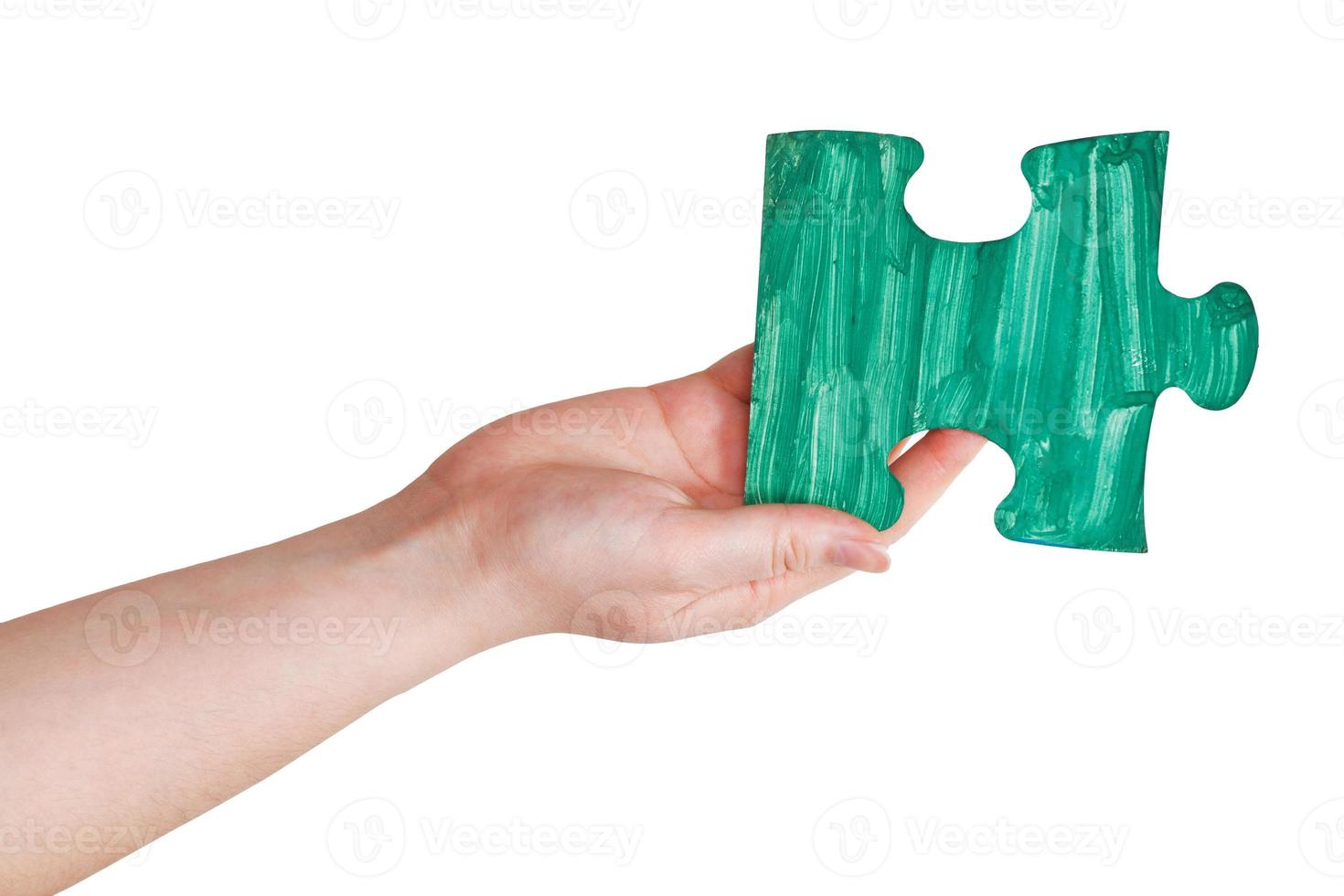 female hand with painted green puzzle piece photo