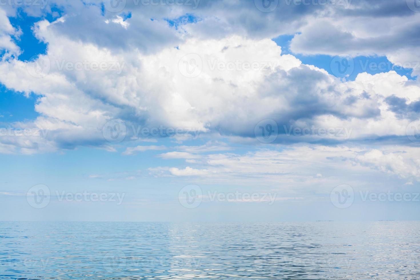 clouds in blue sky over calm water of Azov Sea photo