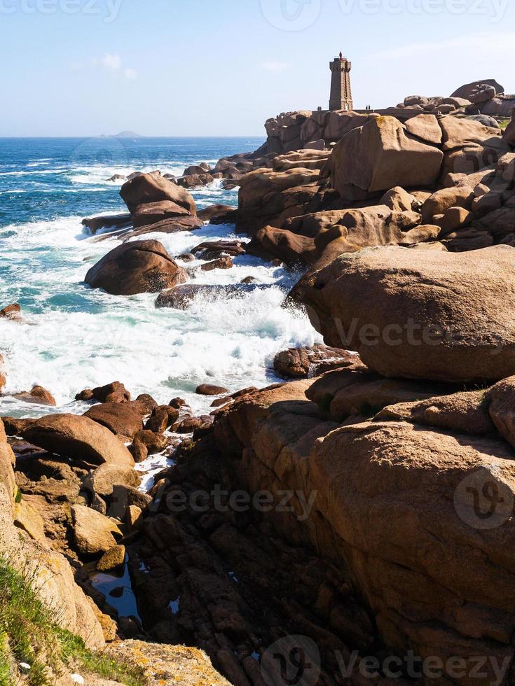 rocky coast of with lighthouse in Ploumanac'h photo