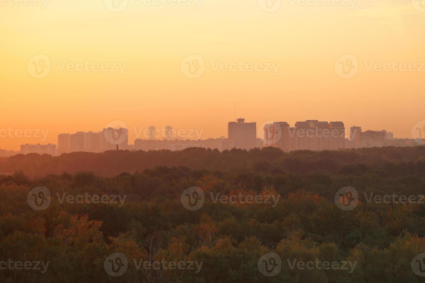 dark orange early sunrise over houses and park photo