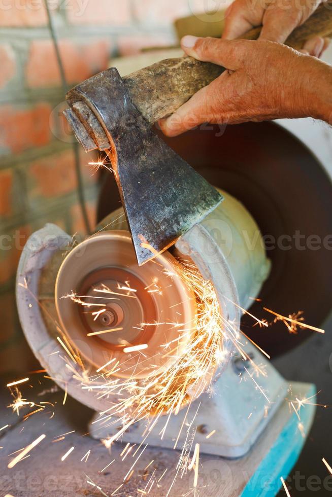 sharpening bench axe using a grinding machine photo