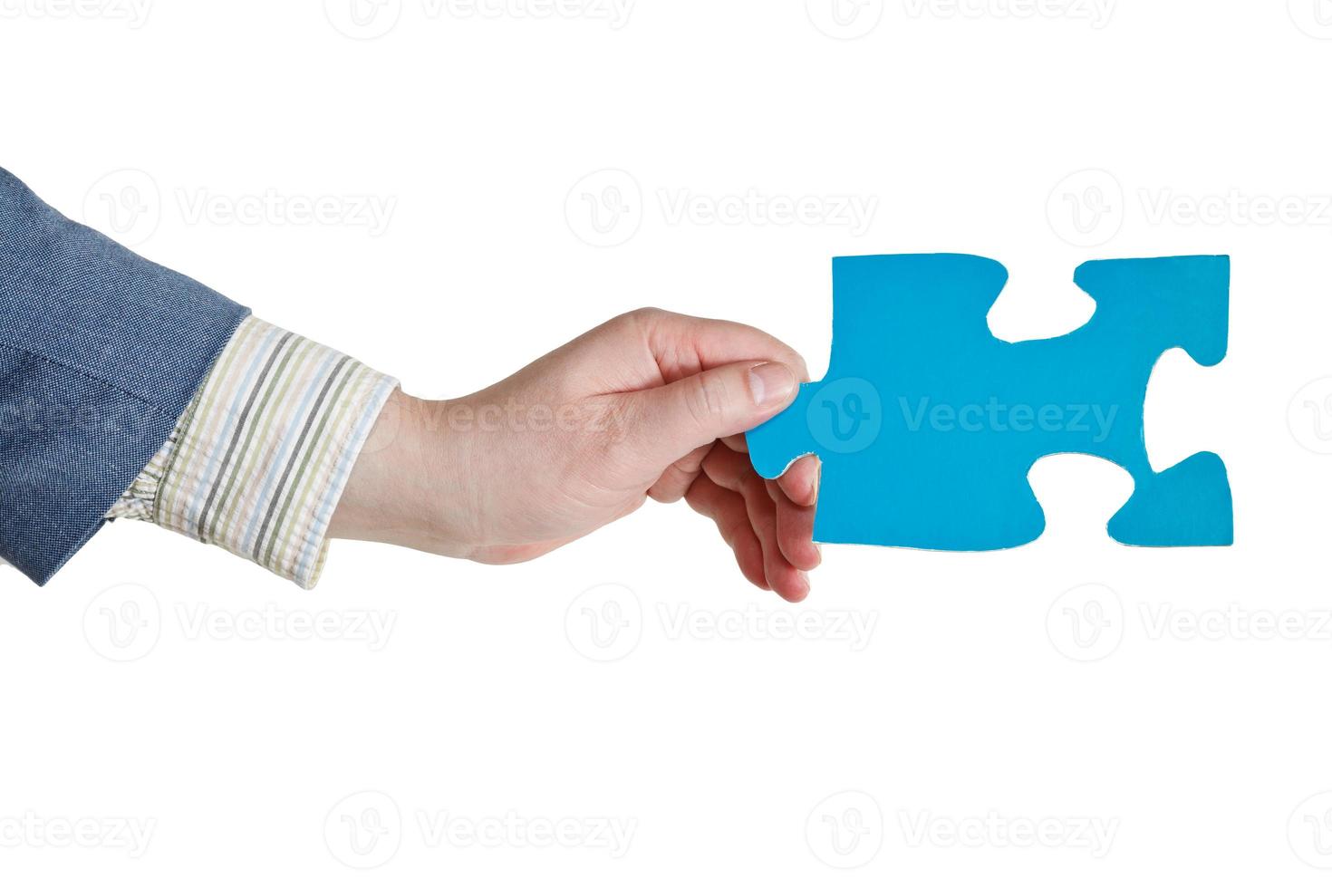 male hand holding big blue paper puzzle piece photo