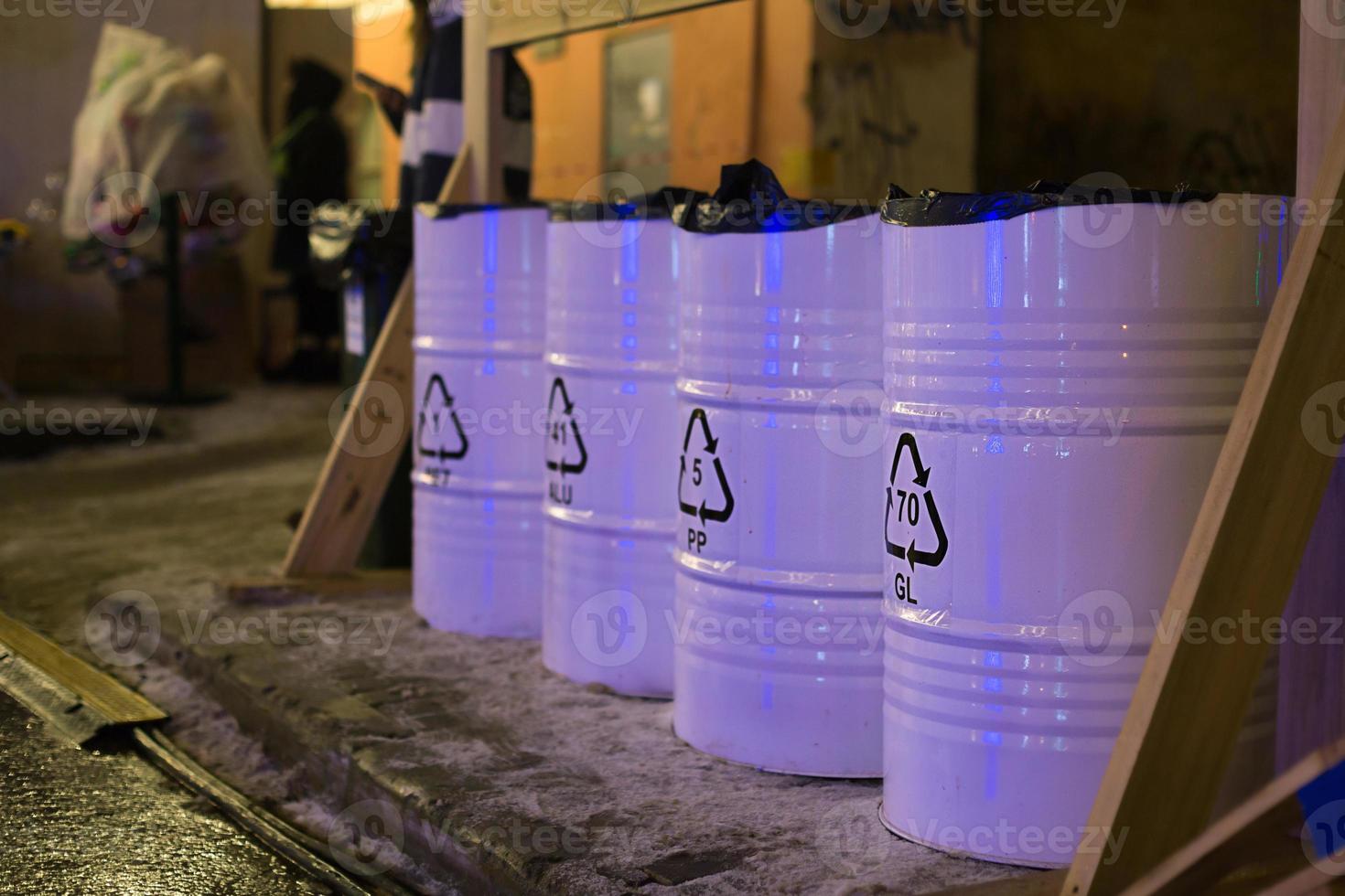 Metal barrels containers for separate collection and sorting of garbage on the street. Environmental awareness photo