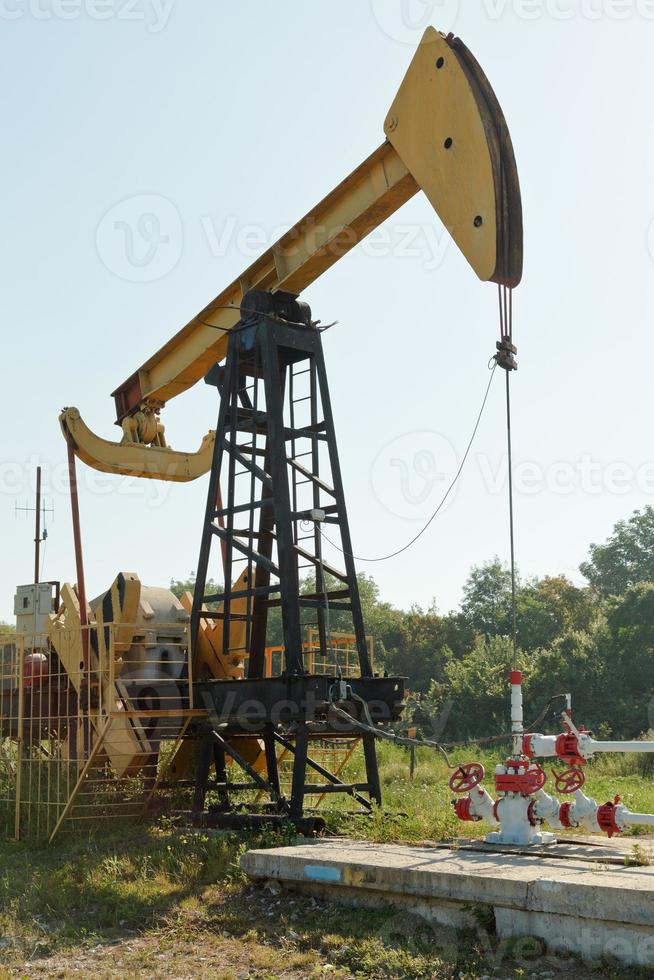 pumpjack pumps oil in foothills of Caucasus photo