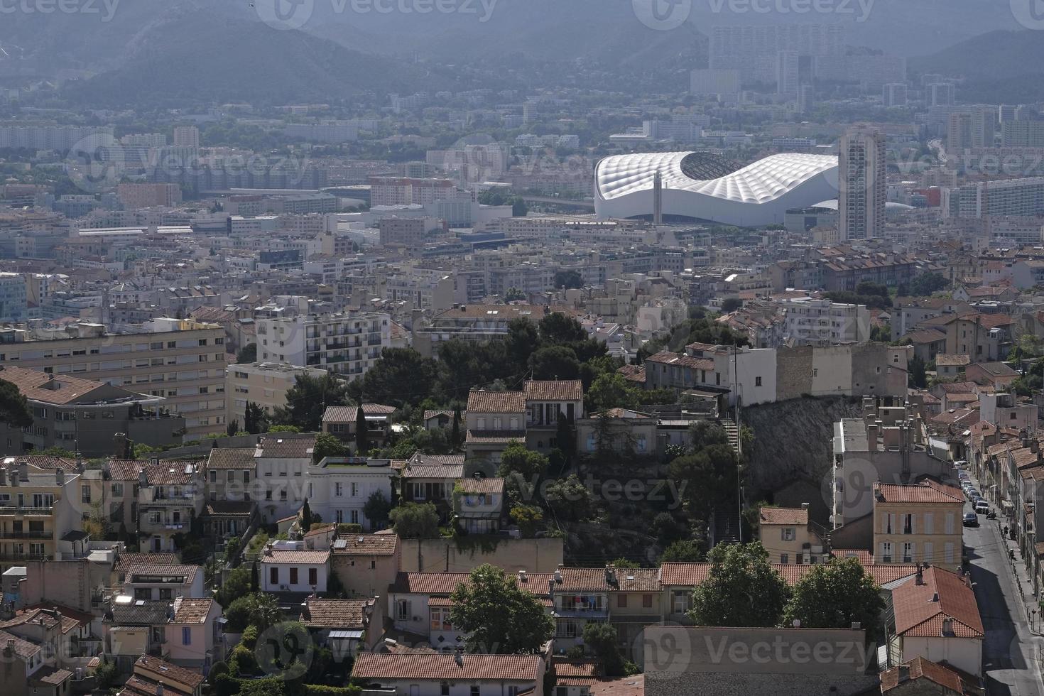 View over the city of Marseille from a hill, with the stadium in the background, and some pollution in the air photo