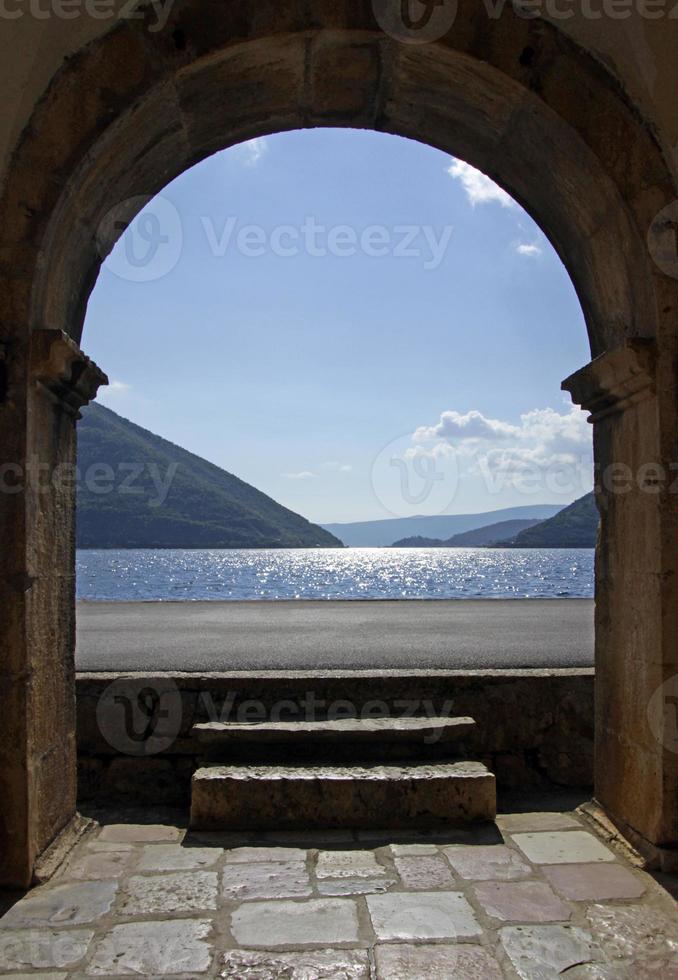 vista de la bahía de kotor, montenegro, desde la entrada de un edificio arqueado en perast. foto