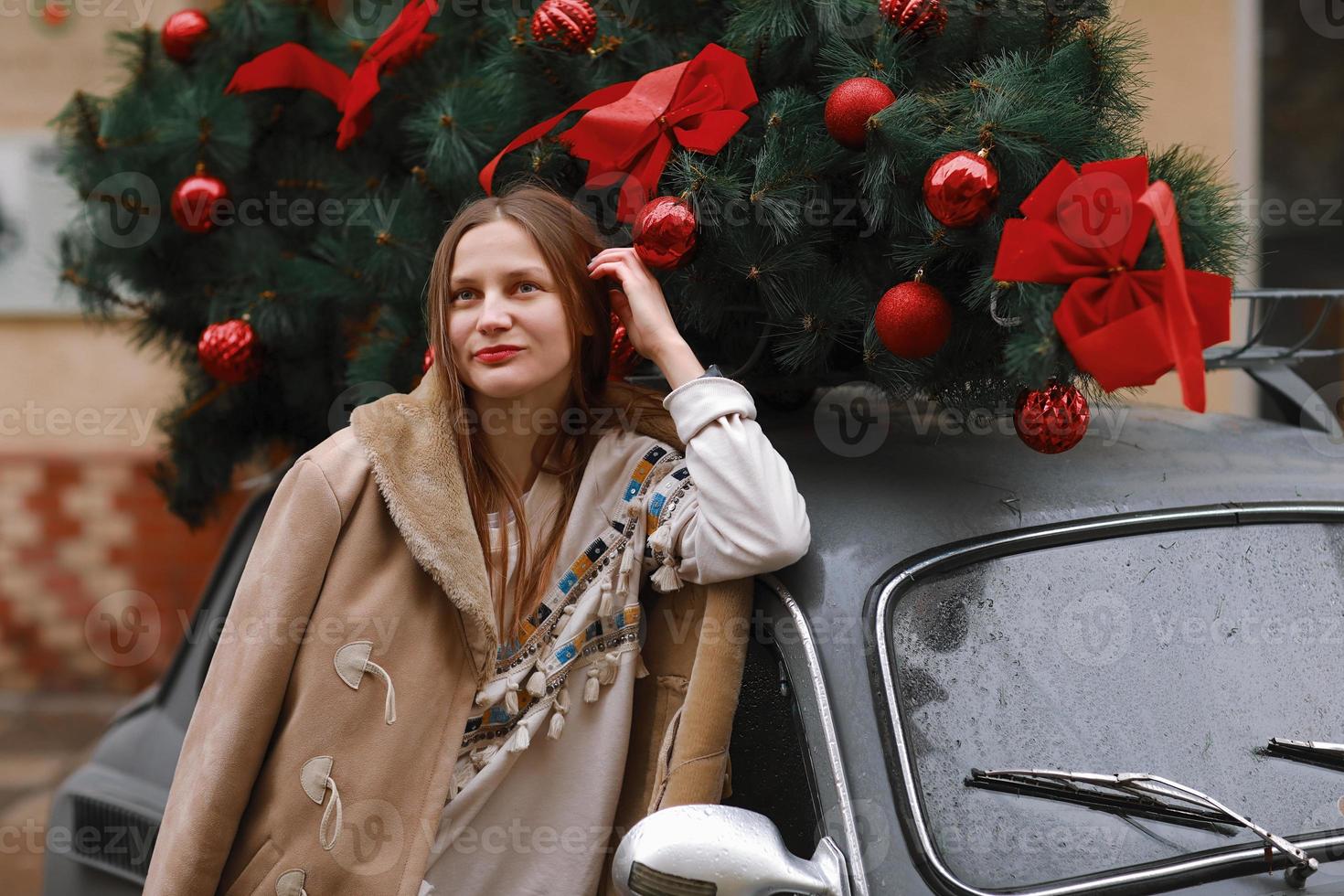 girl on a winter walk in the city, snow, outside. Winter street in the city. happy girl walks in the city on Christmas day. Christmas car with a gift. Happy New Year and Merry Christmas. photo