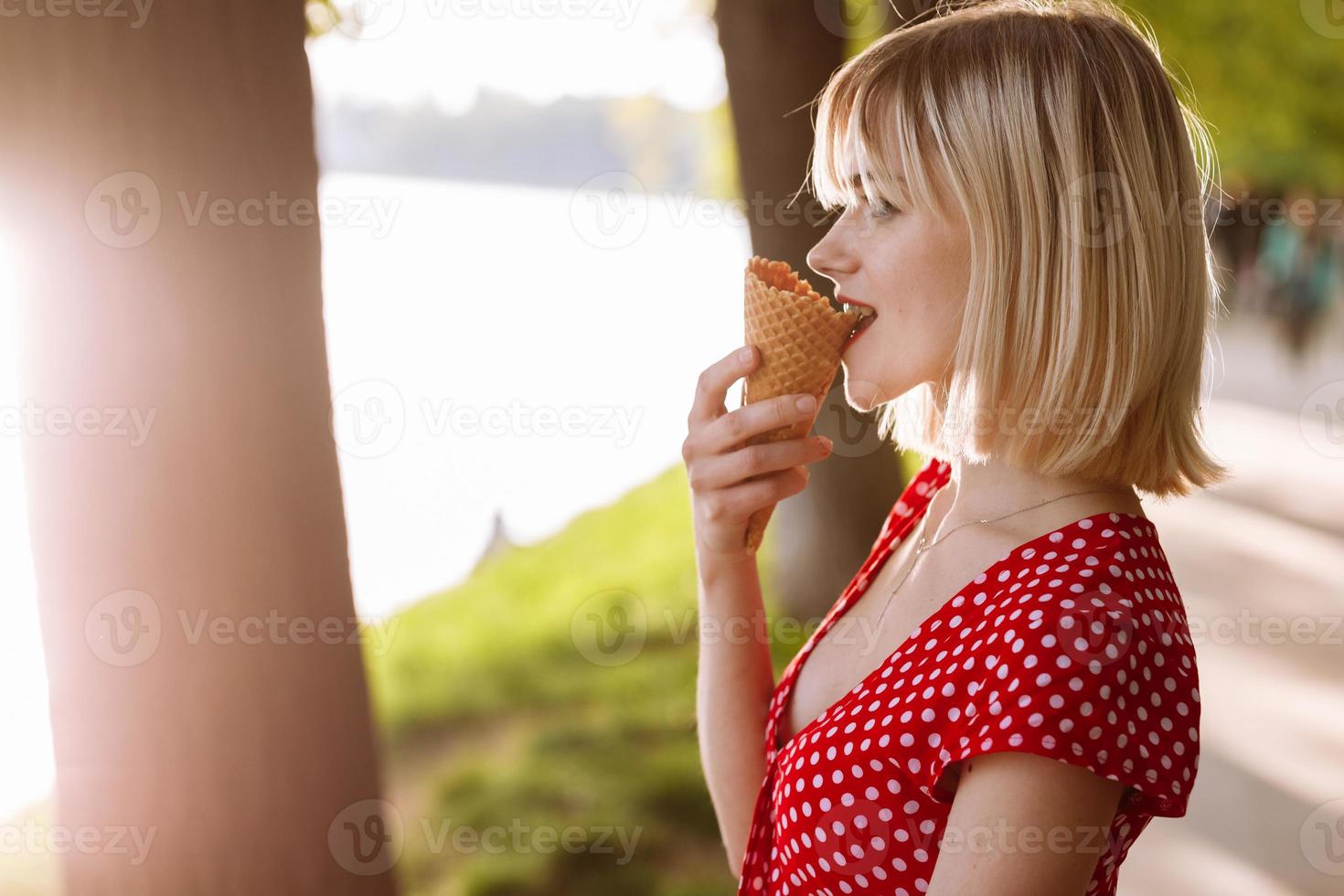 girl with short hair. beautiful young cheerful happy girl eating ice cream smiling in sunny day photo