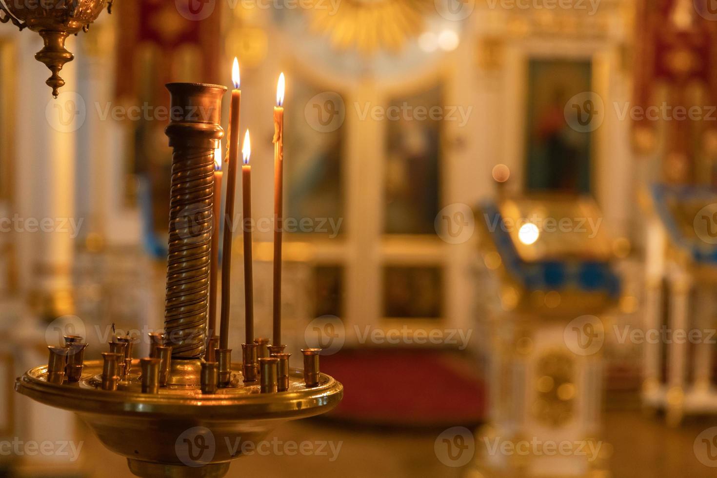 Iglesia Ortodoxa. cristiandad. decoración interior festiva con velas encendidas e icono en la iglesia ortodoxa tradicional en vísperas de pascua o navidad. religión fe orar símbolo. foto