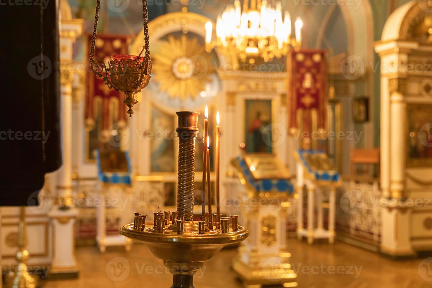 Iglesia Ortodoxa. cristiandad. decoración interior festiva con velas encendidas e icono en la iglesia ortodoxa tradicional en vísperas de pascua o navidad. religión fe orar símbolo. foto