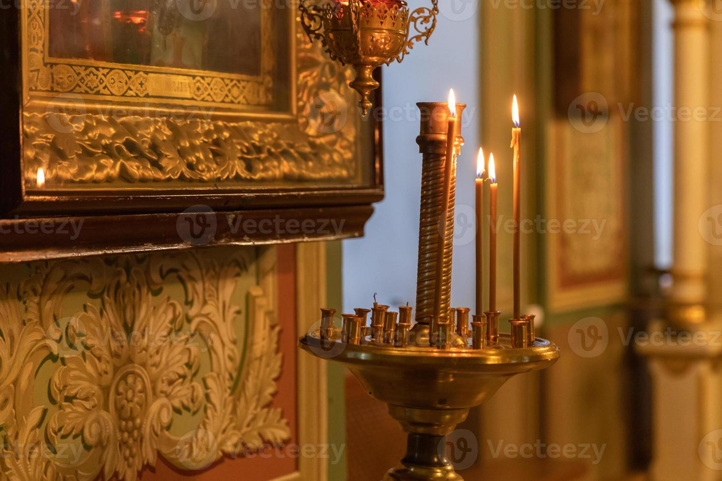 Iglesia Ortodoxa. cristiandad. decoración interior festiva con velas encendidas e icono en la iglesia ortodoxa tradicional en vísperas de pascua o navidad. religión fe orar símbolo. foto