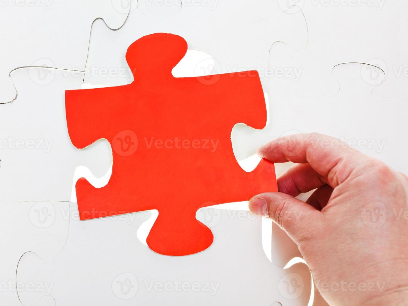 fitting red puzzle piece on free space photo