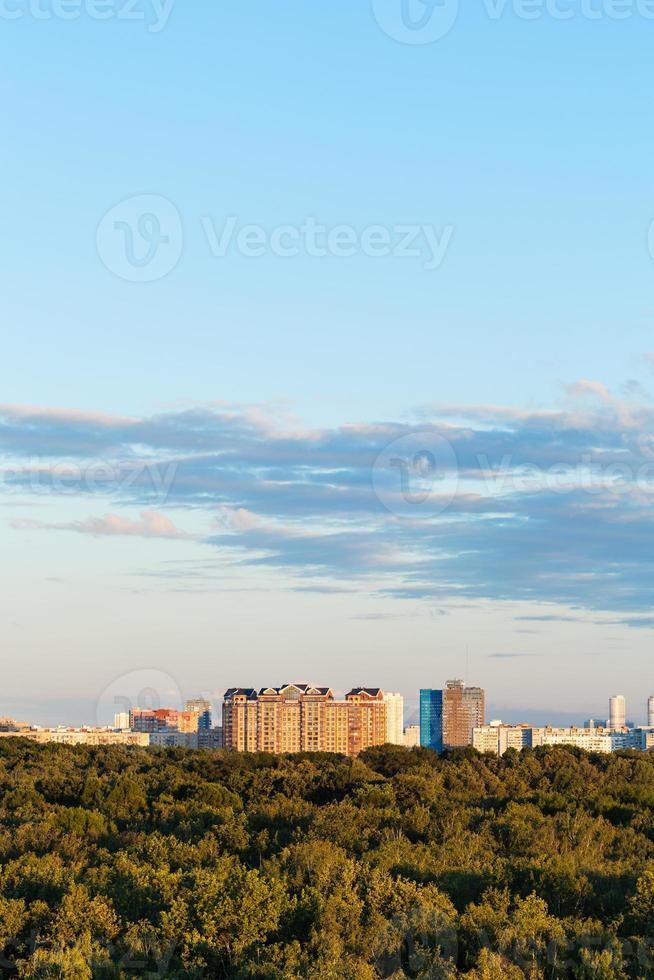 blue sky over city and green forest in summer photo