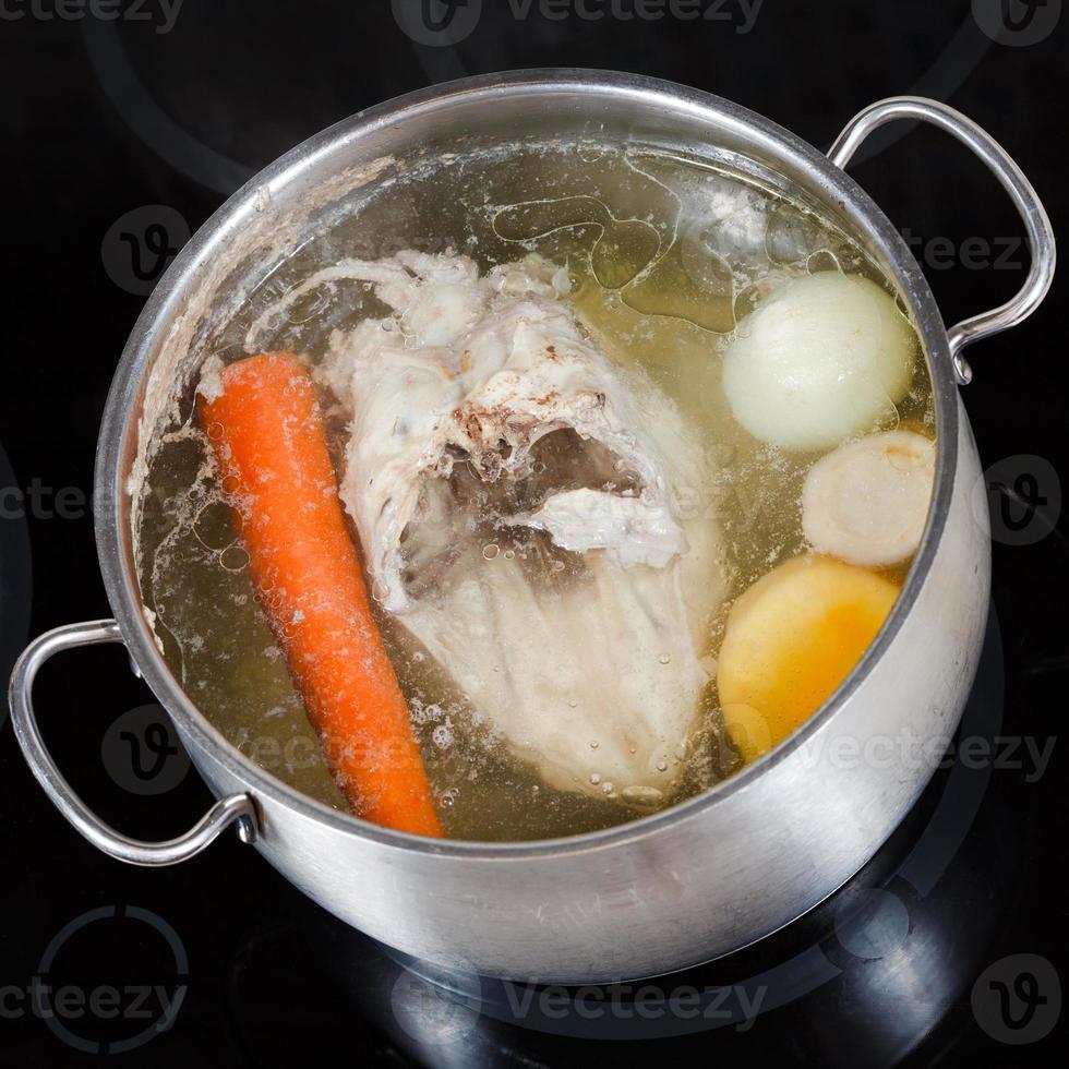 top view of boiling chicken broth in pan photo