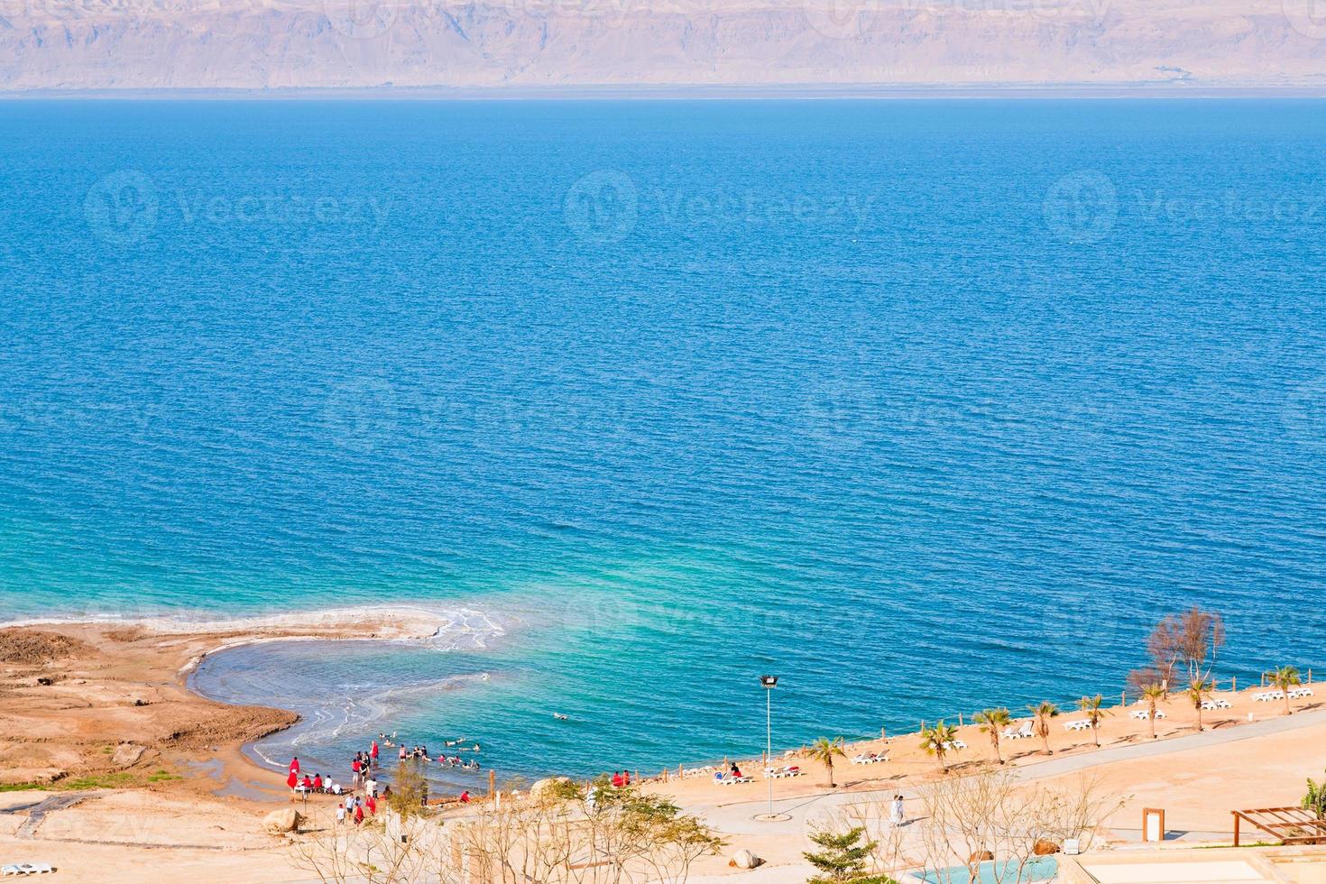 people on sand beach of Dead Sea photo