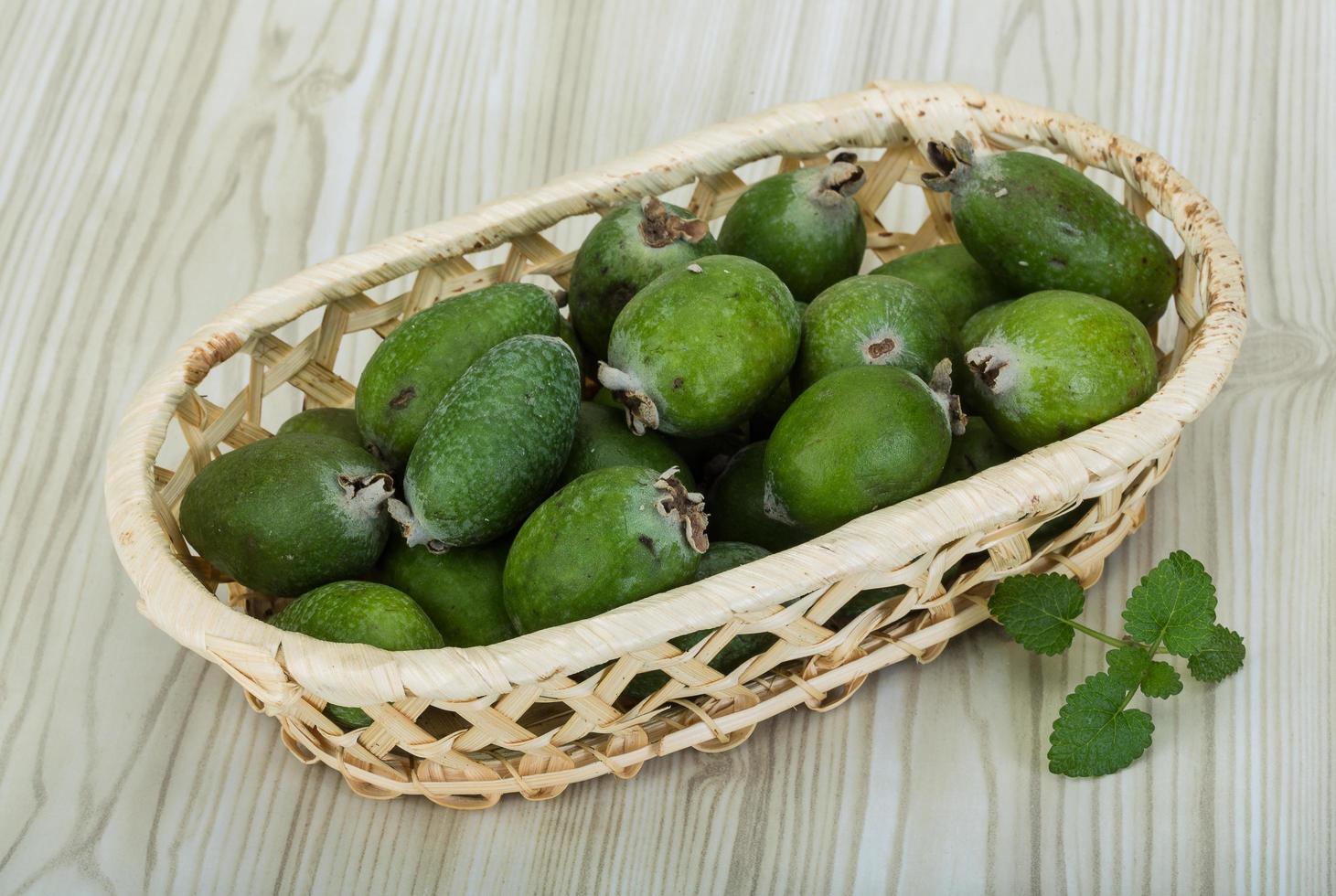 feijoa en una cesta sobre fondo de madera foto