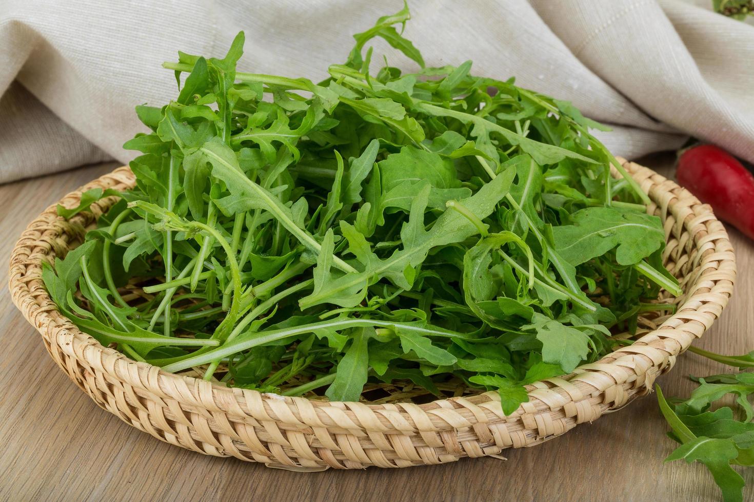 Ruccola in a basket on wooden background photo
