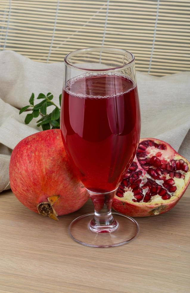 Pomecranet juice on wooden background photo