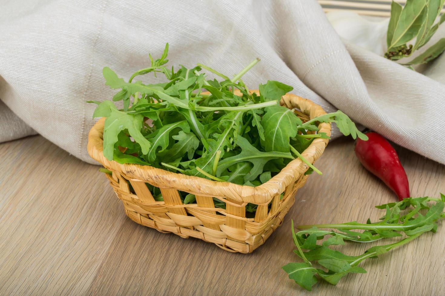 Ruccola in a basket on wooden background photo