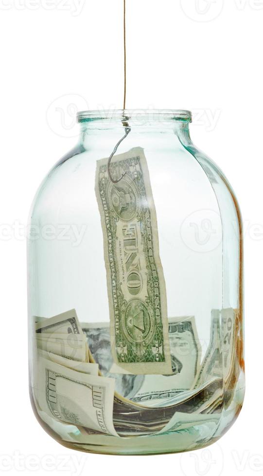 fishing out saving dollars from glass jar photo