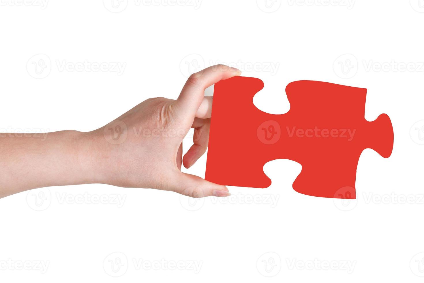 female hand holding big red paper puzzle piece photo