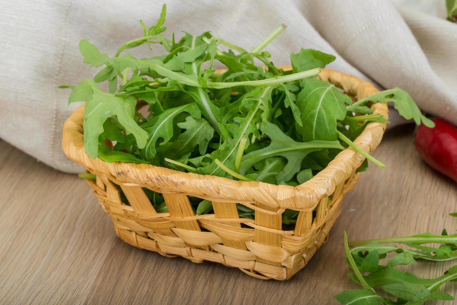 Ruccola in a basket on wooden background photo