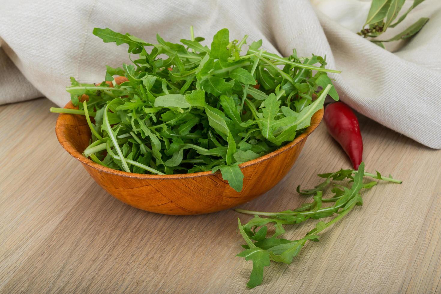 Ruccola in a bowl on wooden background photo